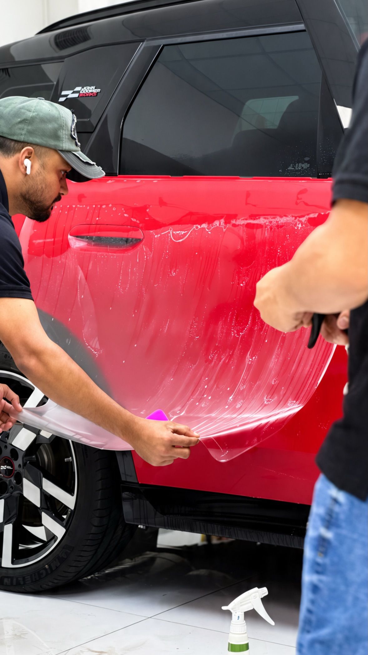 Paint protection film being installed on a red car bonnet at Apex Detail Studio Dubai