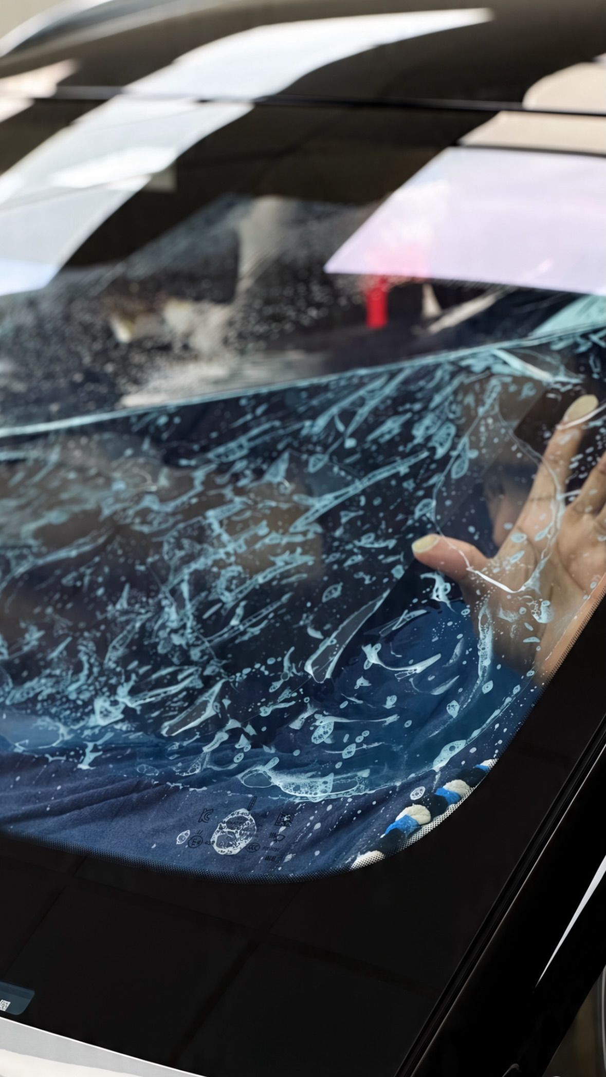 Installer cutting window tint film on car glass at Apex Detail Studio Dubai