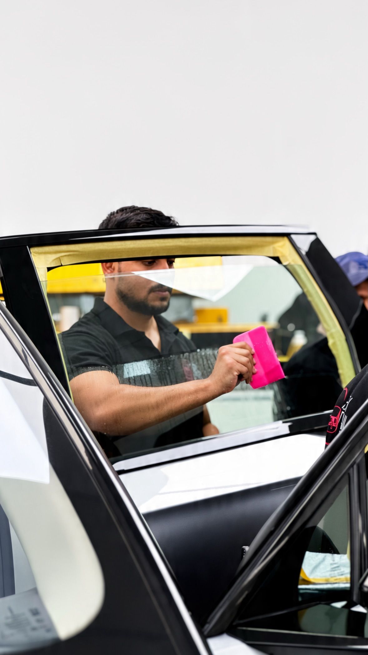 Window film being fitted to a car door at Apex Detail Studio