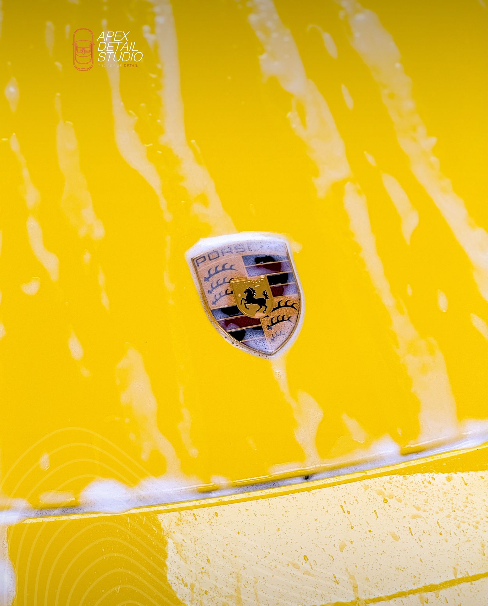 Yellow Porsche bonnet with crest protected by paint protection film at Apex Detail Studio Dubai
