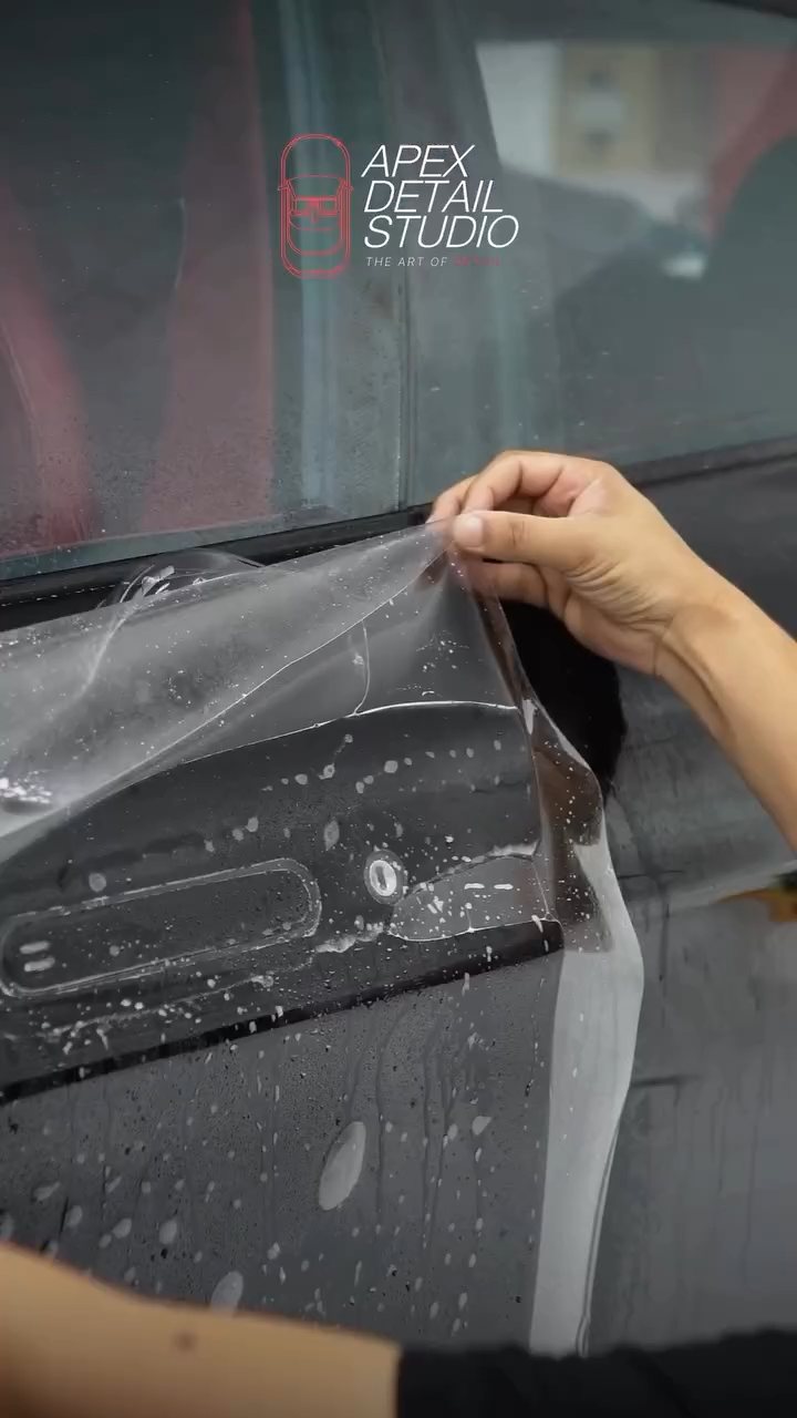 Hand lifting PPF to reposition it on the Aston Martin Rapide door