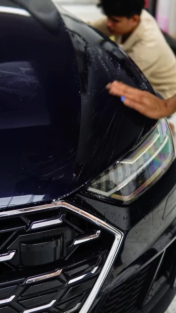 Detailer preparing the dark blue Audi A7 front for ceramic coating at Apex Detail Studio Dubai