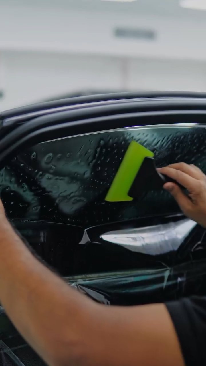 Window tint being squeegeed on the Audi A8 L door glass in Dubai