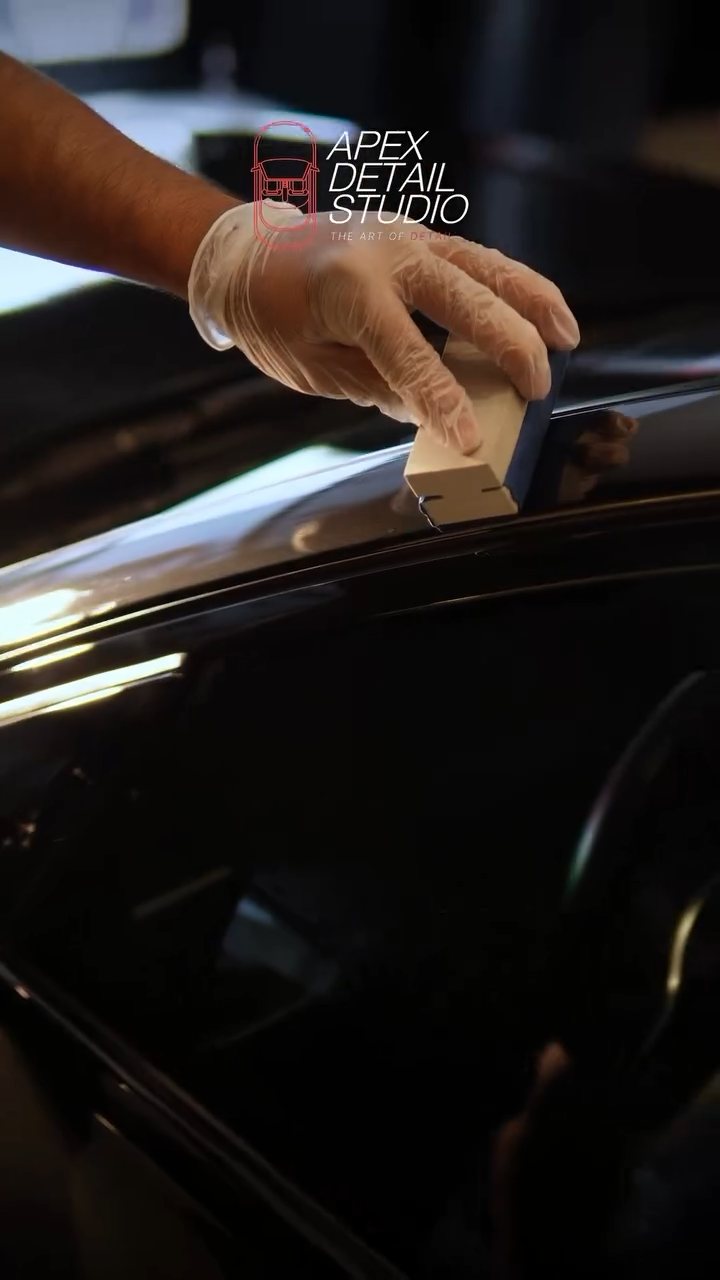 Detailer applying Gtechniq ceramic coating to the black BMW bonnet