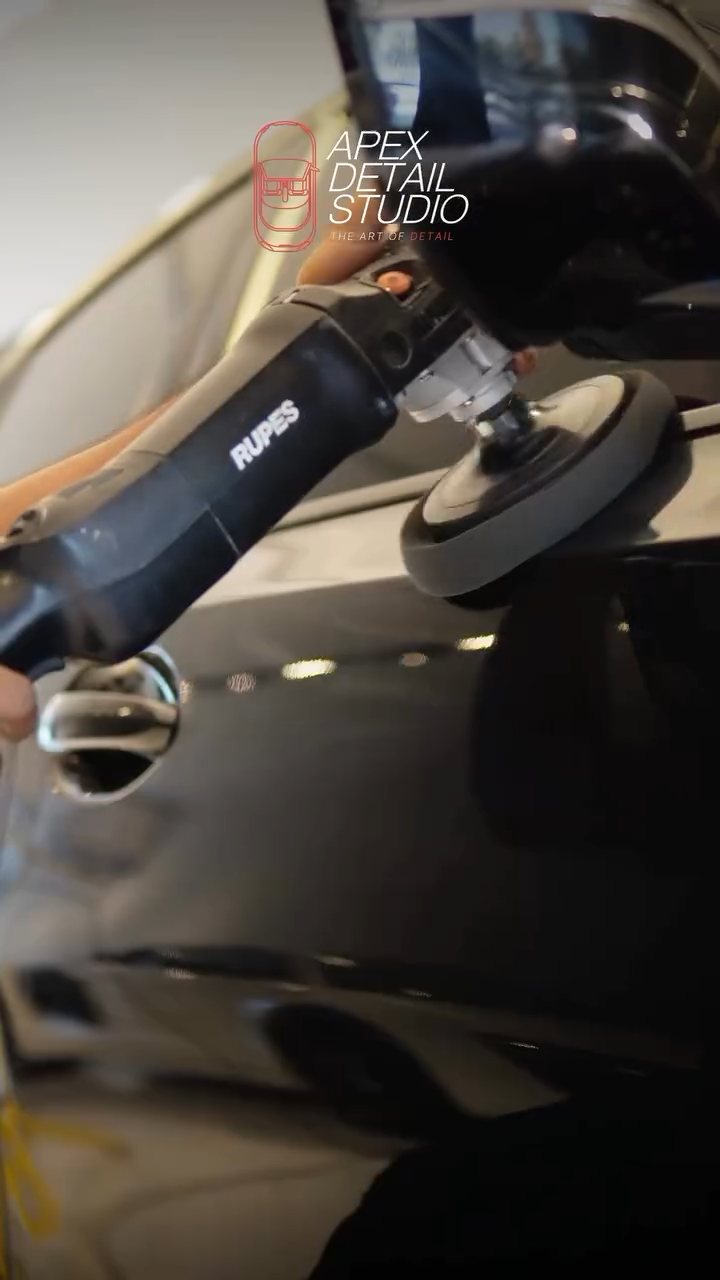 Dual action polisher on the black BMW side panel at Apex Detail Studio