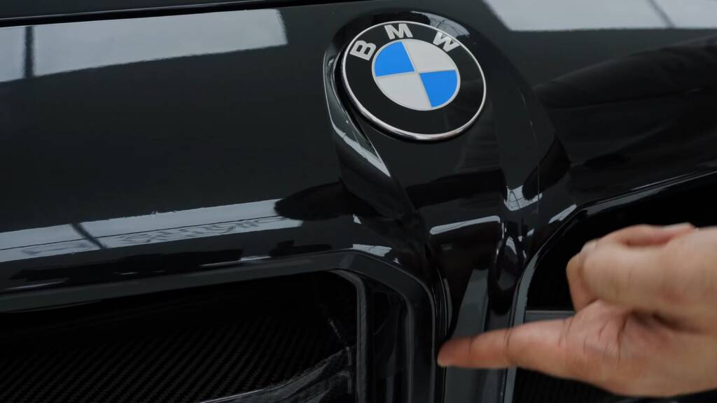 Pointing out a bad PPF edge at a BMW M2 grille