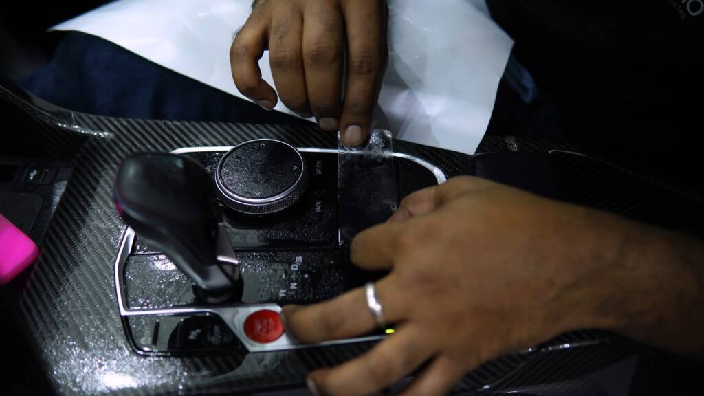 Protection film being fitted to the centre console of a BMW M2 CS