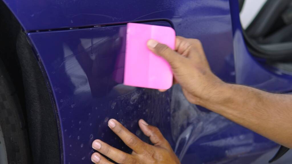 Squeegee on PPF on the rear quarter of a BMW M2 CS