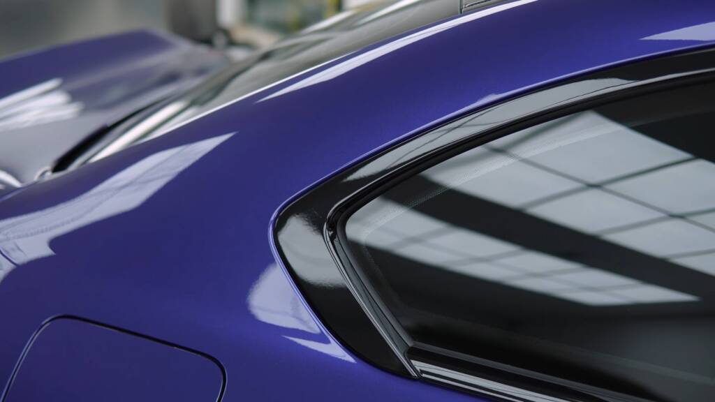 Rear side window and body line of a blue BMW M2 CS