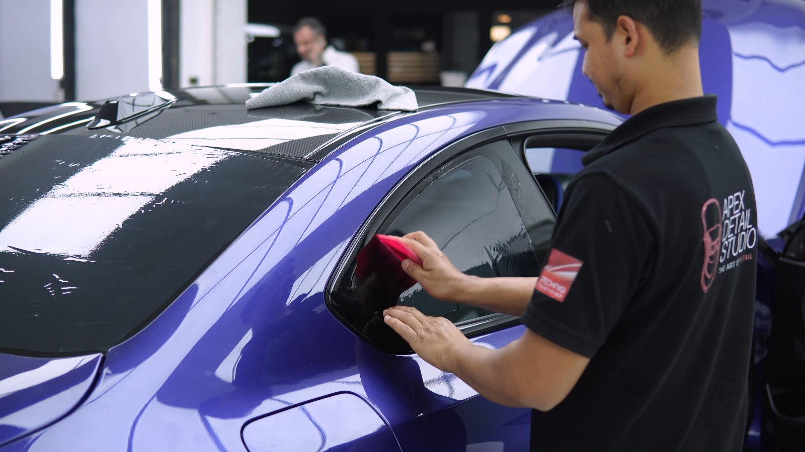 Apex technician finishing the window tint edges on a BMW M2 CS