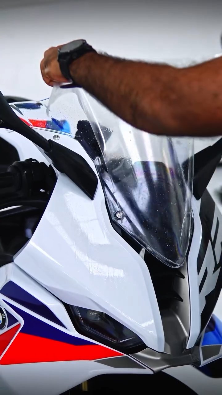 Installer fitting PPF on the BMW S1000RR nose fairing at Apex Detail Studio Dubai