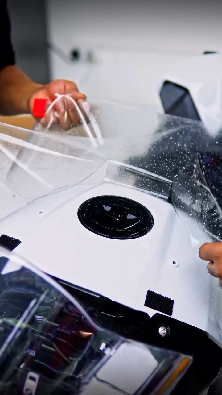 Installers laying PPF over the BMW S1000RR fuel tank at Apex Detail Studio Dubai