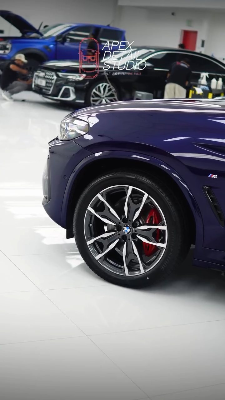 Coated blue BMW X4 front wheel and wing in the Apex studio, Dubai