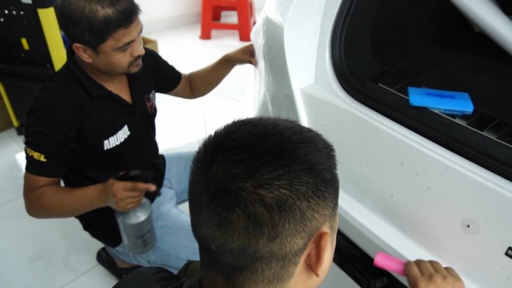 Two installers fitting PPF on the 2024 BMW X6 M Competition rear at Apex Detail Studio Dubai