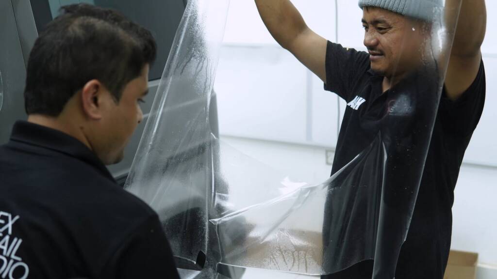 Installer stretching PPF over the rear quarter of a Brabus G800, Dubai