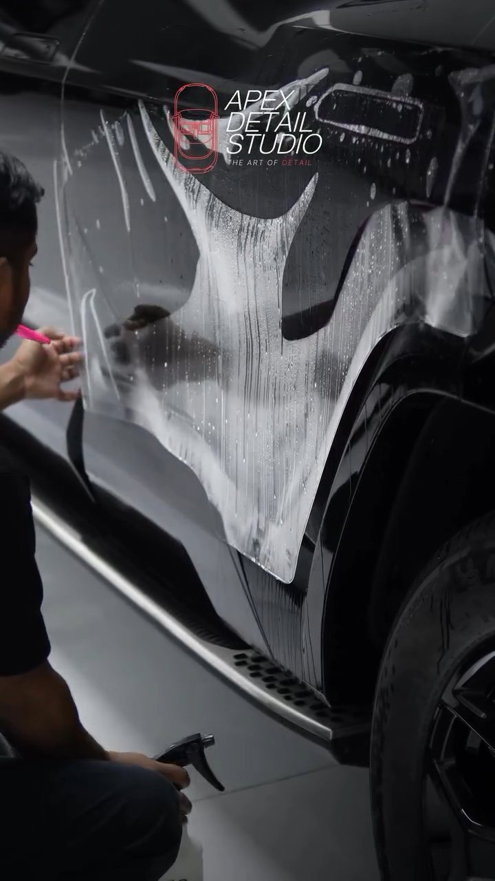 Two installers stretching PPF over the Denza B8 rear door