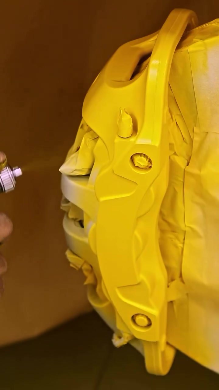 Brake caliper being painted yellow for a Ferrari 488 GTB