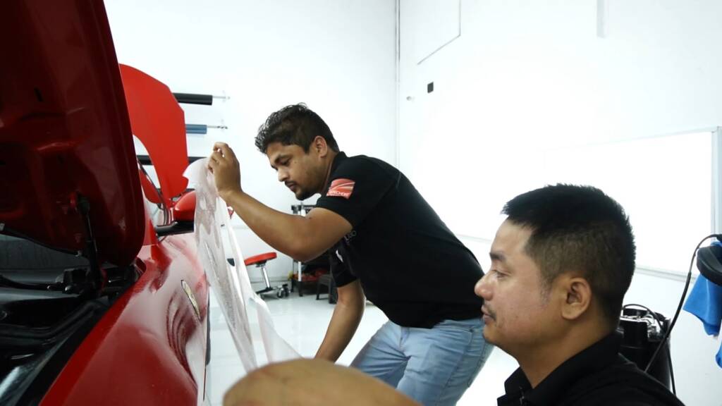 Two installers preparing film for a Ferrari Portofino
