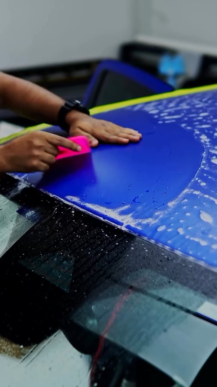 Squeegeeing matte PPF on the blue Ford Raptor bonnet in Dubai