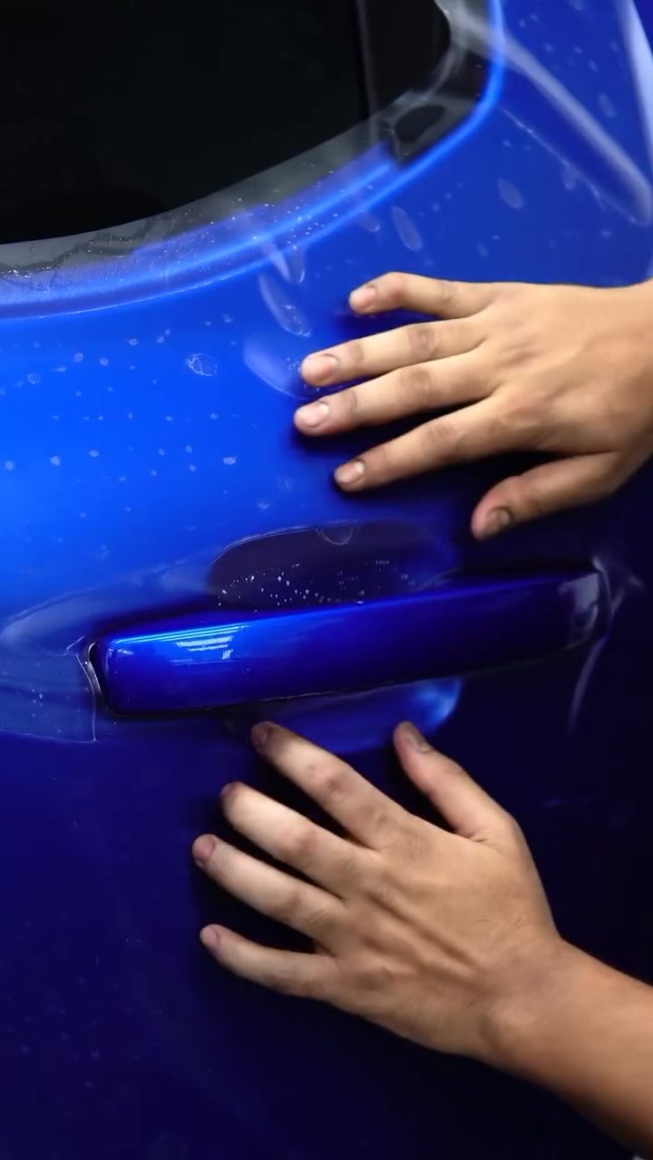 Hands pressing matte PPF into the Ford Raptor door handle recess at Apex Detail Studio Dubai