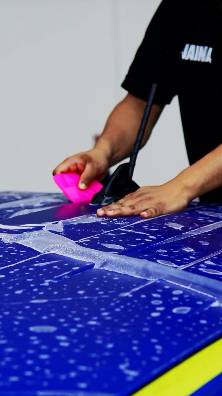 Installer squeegeeing a large matte PPF panel for the Ford Raptor