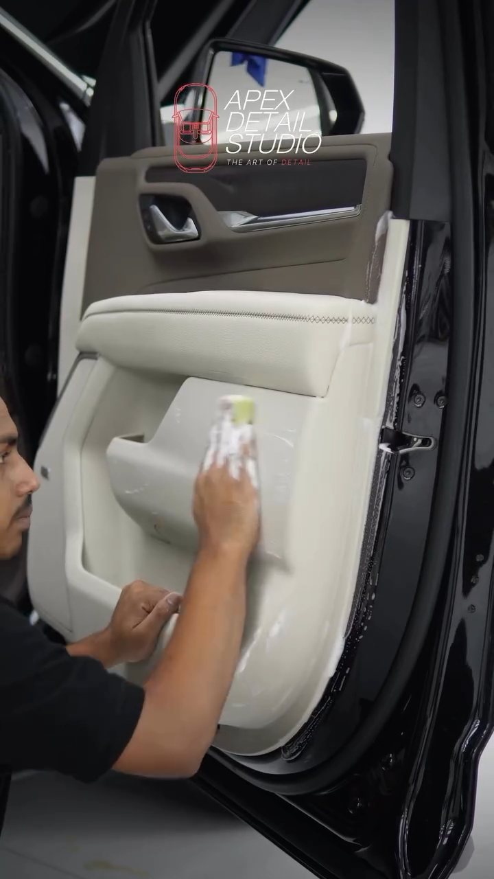 Detailer cleaning the GMC Denali door card leather in Dubai