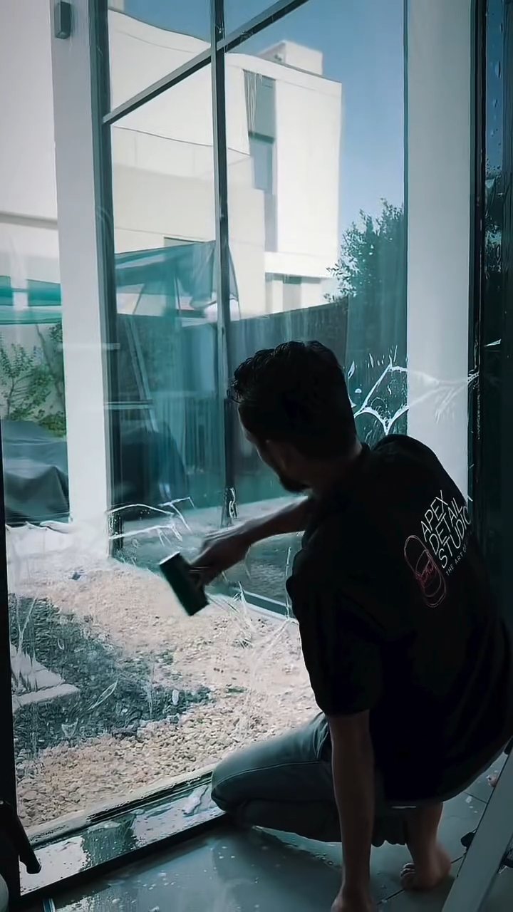 Apex installer finishing the bottom edge of a home window film in Dubai