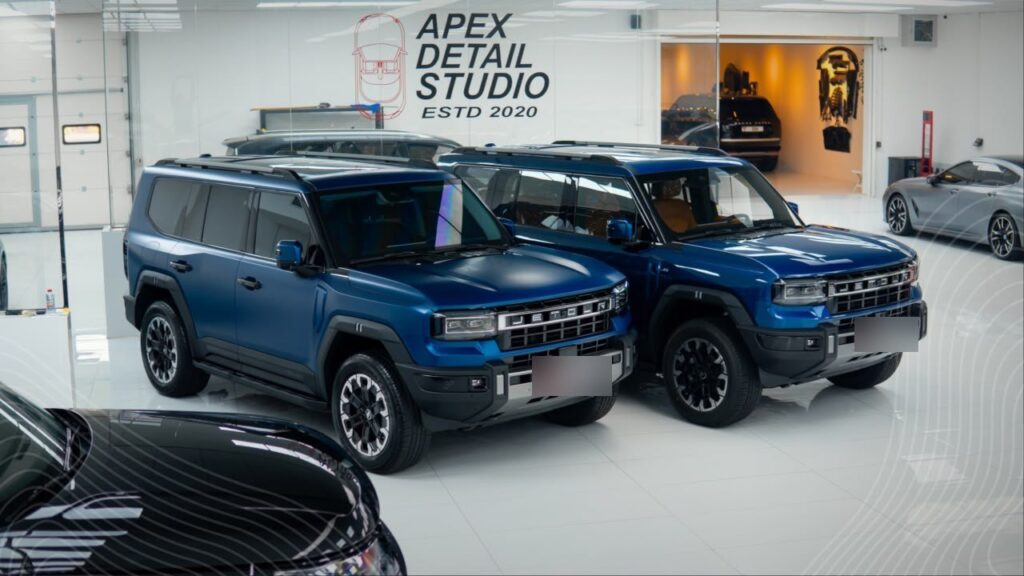 Two blue Jetour G700s at Apex Detail Studio Dubai, matte PPF on the left and gloss on the right