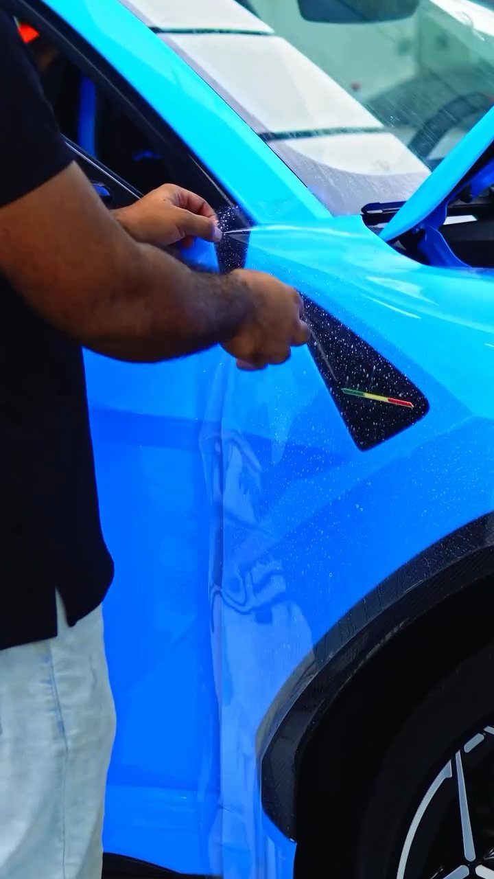 Installer working PPF at the Lamborghini Urus Performante pillar at Apex Detail Studio
