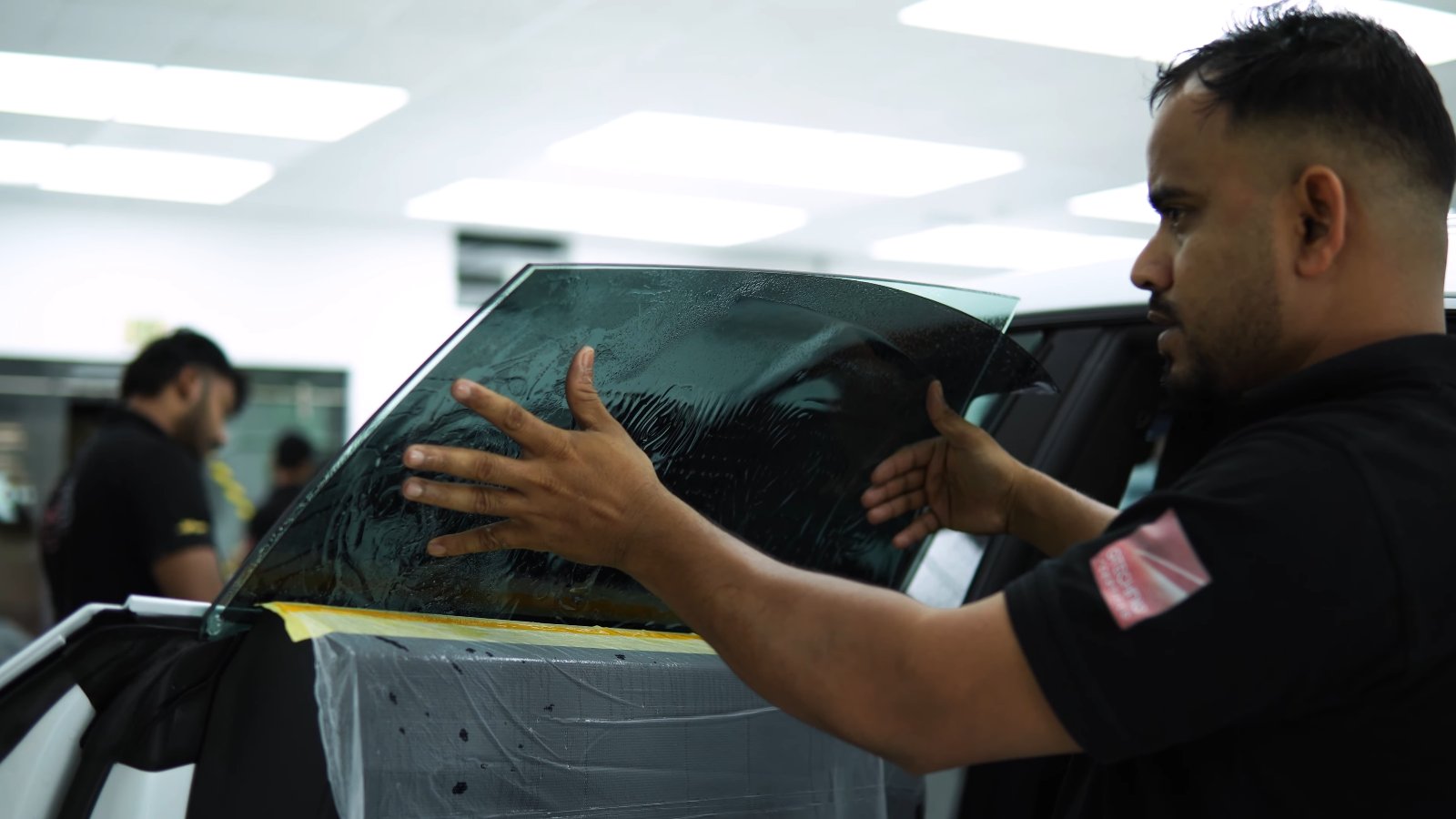 Window tint being fitted to the door glass of a Lamborghini Urus SE in Dubai