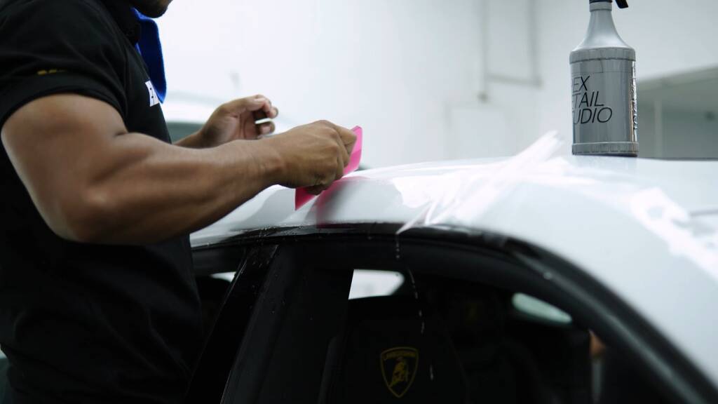 Installer working PPF on the rear quarter of a Lamborghini Urus SE