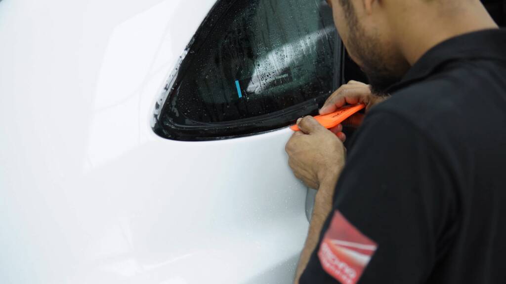 Installer trimming PPF around the tail light of a Lamborghini Urus SE