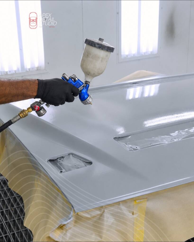 Spraying the bonnet of the Lancia Delta Integrale in Nardo Grey in the paint booth at Apex Detail Studio Dubai