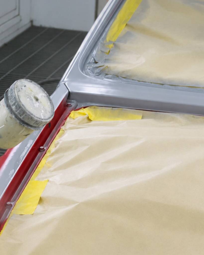 Masking tape and paper on the red Lancia Delta Integrale in the paint booth at Apex Detail Studio Dubai