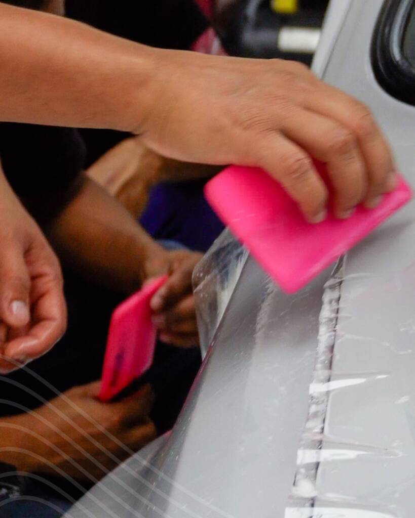 Close up of a squeegee pushing water out from under PPF on the Lancia Delta Integrale at Apex Detail Studio Dubai