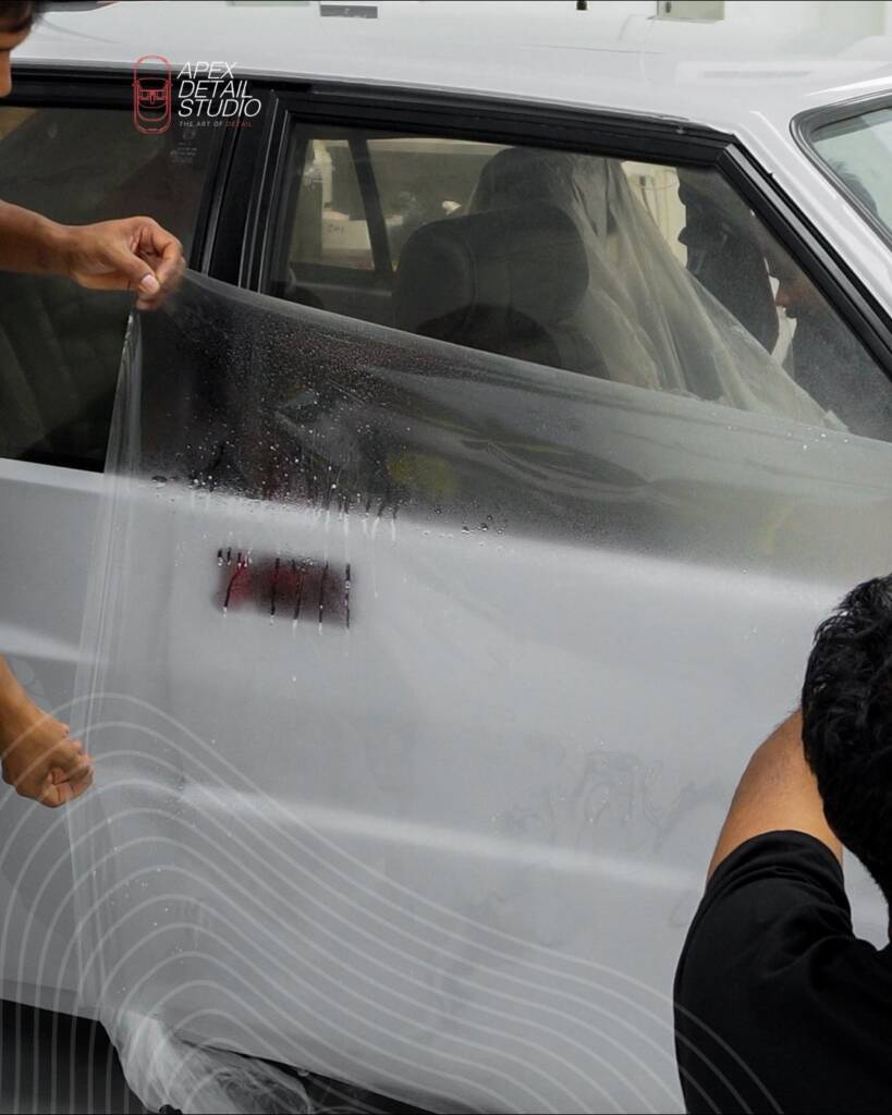 Paint protection film being laid on the door of the Nardo Grey Lancia Delta Integrale at Apex Detail Studio Dubai