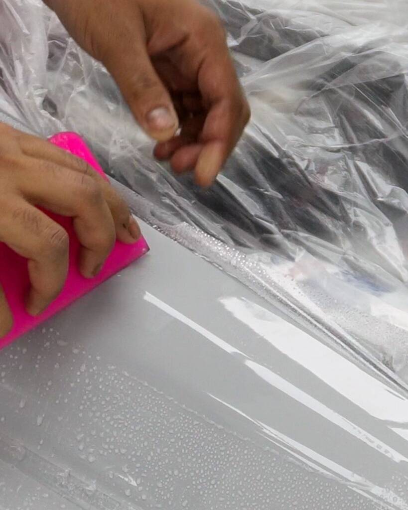 Installer positioning paint protection film by hand on the Lancia Delta Integrale at Apex Detail Studio Dubai