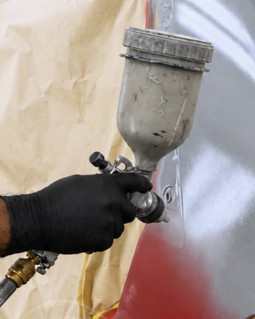 Spray gun applying Nardo Grey paint to the Lancia Delta Integrale at Apex Detail Studio Dubai
