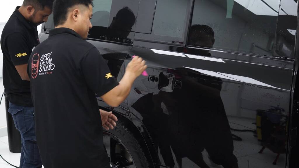 Two installers working on a Land Rover Defender 130