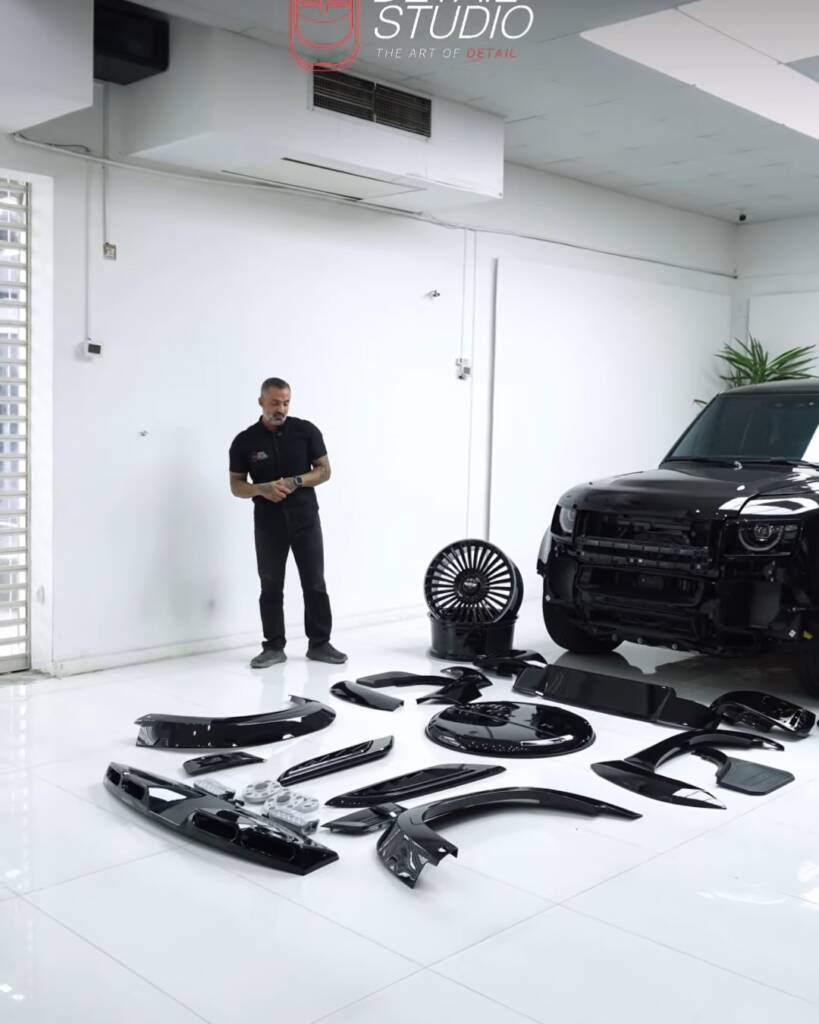 Full body kit laid out on the studio floor next to a 2026 Land Rover Defender, Dubai