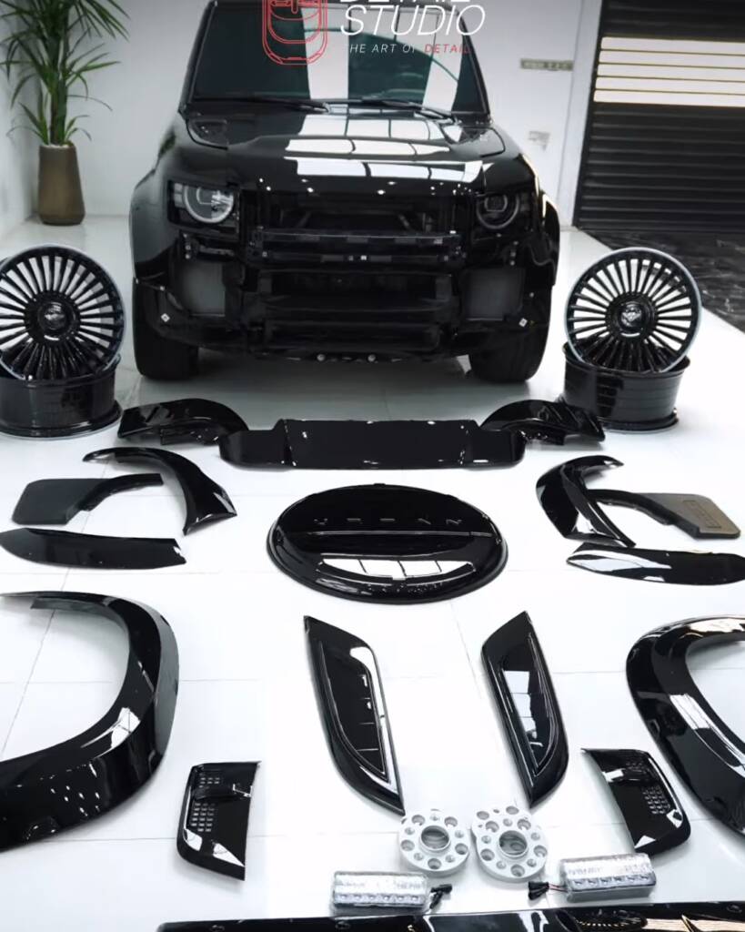 Body kit parts, wheels and spacers in front of a black 2026 Land Rover Defender, Apex Dubai
