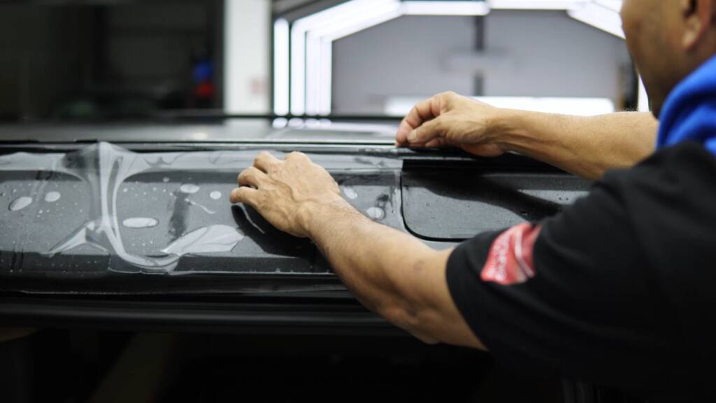 Installer laying PPF on the bonnet of a 2026 Land Rover Defender, Dubai