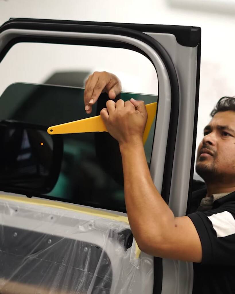 Window tint finishing on a Defender door glass with card, Apex Detail Studio