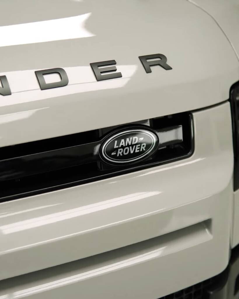 Land Rover badge and grille on a white 2026 Defender after window tint, Dubai