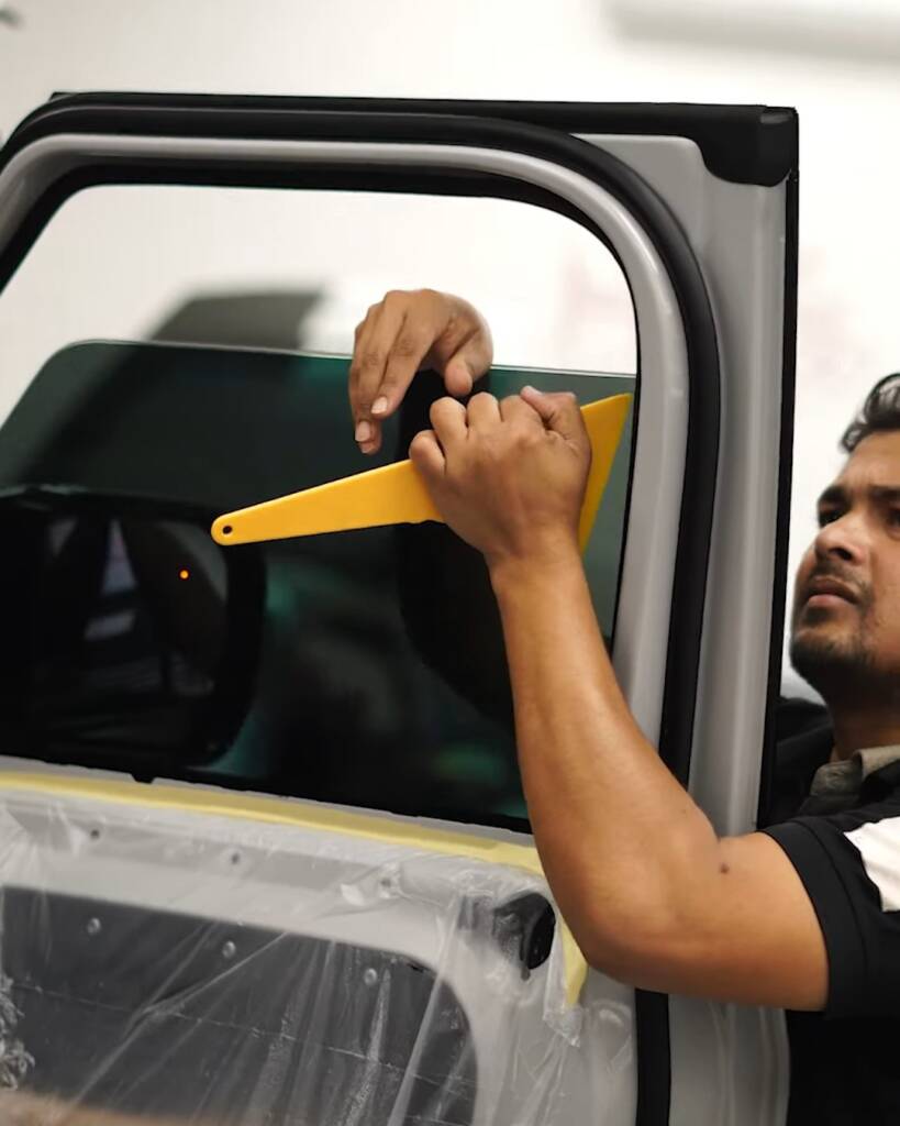 Installer working window tint with a hard card on a 2026 Land Rover Defender, Dubai