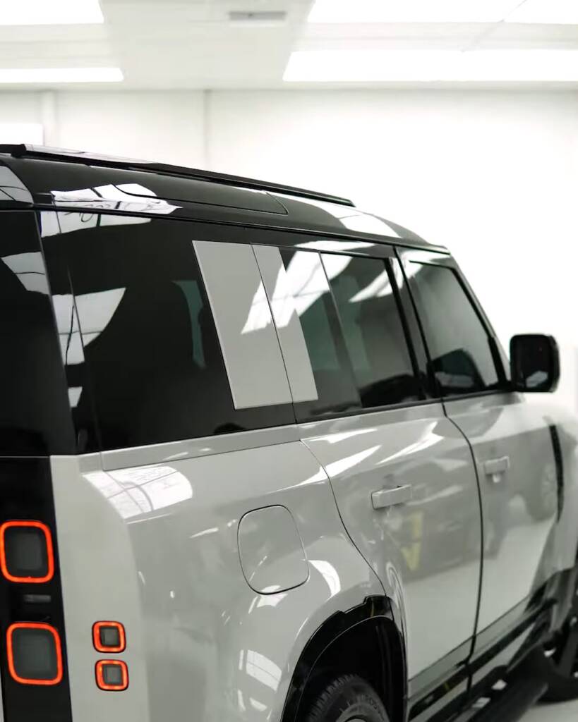 Rear three quarter of a 2026 Land Rover Defender with tinted windows, Apex Dubai