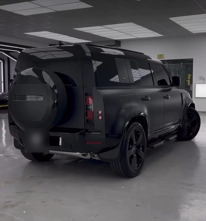 Rear view of a blacked-out Land Rover Defender with black spare wheel cover at Apex Detail Studio Dubai