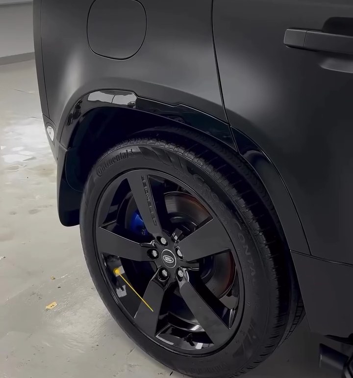 Black painted wheel and rear wheel arch on a blacked-out Land Rover Defender at Apex Detail Studio Dubai