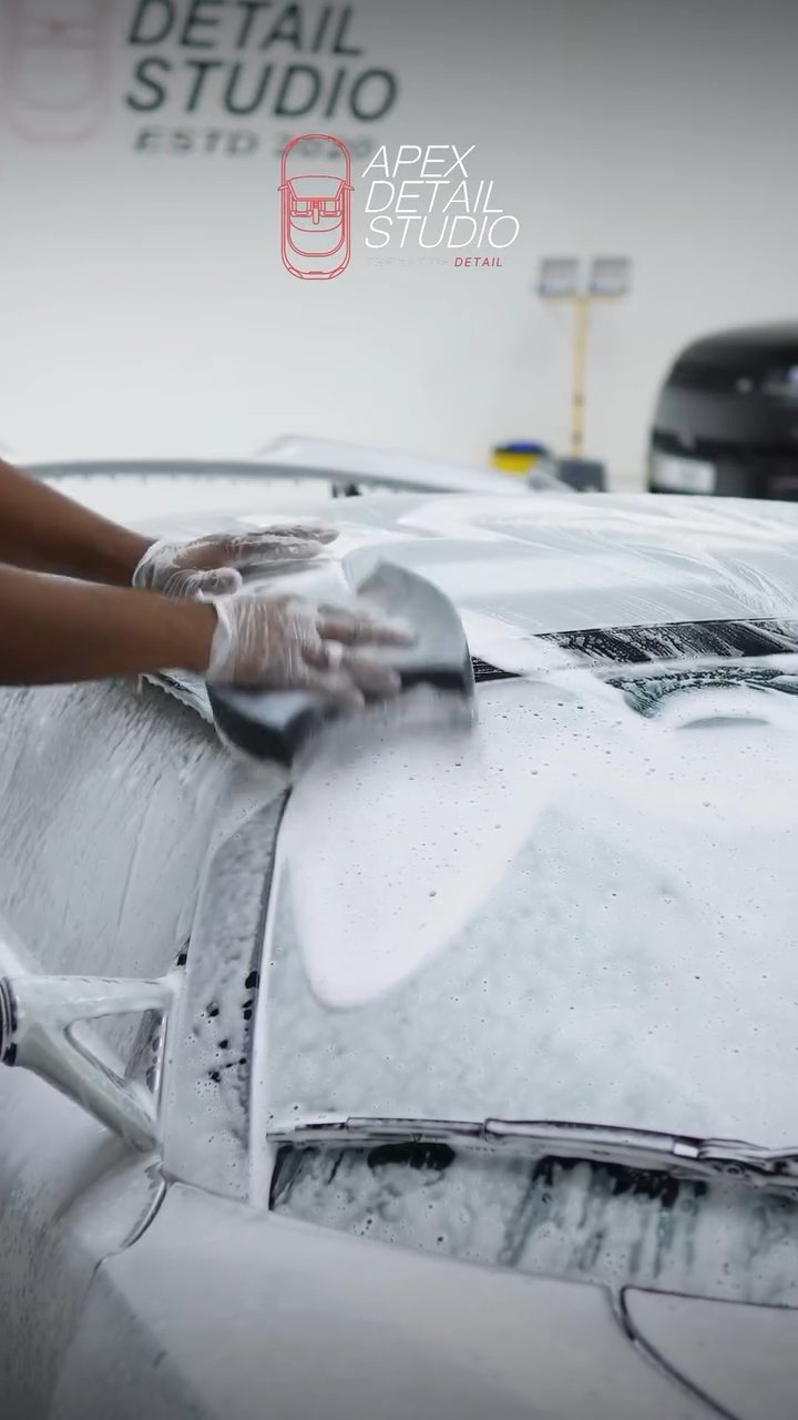 Gloved hand washing the Lotus Exige with a wash mitt in Dubai