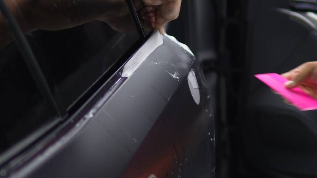 Matte paint protection film being wrapped around the door edge of a BMW M5 Touring